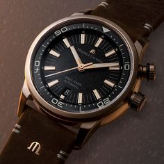 The Maurice Lacroix Pontos S Diver Watch in Bronze, with a 42mm case, epitomizes continuous improvement and accessible luxury. This elegant timepiece, driven by the automatic ML115 movement, features hours, minutes, seconds, and a date function at 6 o'clock, with a 38-hour power reserve and 28'800 vph frequency. Its 13mm thick bronze case, water-resistant to 300m, is complemented by a unidirectional rotating bezel, screwed crown, and a special engraving on the case back. The black lacquered dial, adorned with vintage beige Super-LumiNova indexes and yellow gold-plated hands, ensures readability. Finished with a 22mm brown leather strap featuring the Maurice Lacroix 'M' logo and a bronze pin buckle, this watch blends sumptuous materials with refined finishes, embodying sophistication and el Timeless Watch Bands With Analog Display And Round Dial, Timeless Analog Watch Accessories, Timeless Analog Display Watch Accessories, Timeless Watch Accessories With Analog Display, Timeless Automatic Chronograph Watch, Timeless Chronometer Watch With Round Dial, Luxury Watches With Analog Display, Timeless Watch Accessories With Date Indicator, Luxury Hampers