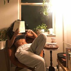 a person sitting in a chair reading a book