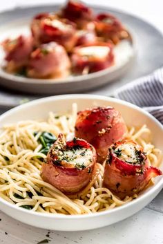 two white bowls filled with food on top of a table