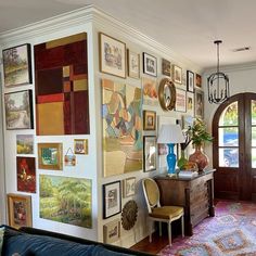 a living room filled with furniture and pictures on the wall