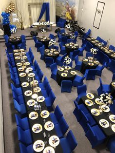 a banquet room with blue chairs and black tables