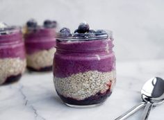 three jars filled with blueberries and oatmeal sitting on top of a table