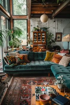 a living room with couches, rugs and potted plants on the floor