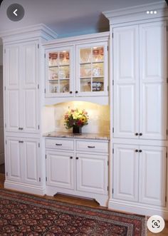 a kitchen with white cabinets and an area rug