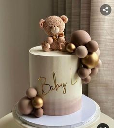 a baby shower cake with a teddy bear on top