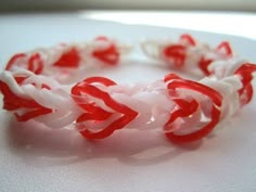 a red and white braided bracelet sitting on top of a table