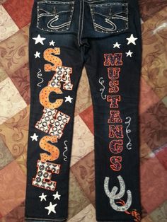 a pair of jeans with the word orange painted on them