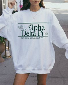 the adpi (social club ♡ Super soft sweatshirt comes in unisex sizing! Reference the size chart for additional details. It is recommended to SIZE UP for an oversized fit   ♡ Sweatshirt comes in white with a forest green print. Please check listing photos for color reference! ♡ Please make sure you are ordering for the correct sorority before placing an order! We are unable to accept returns or exchanges for this since all items are made to order.   ♡ INSTRUCTIONS FOR CARE:  1. Turn inside out bef Cotton Sorority Sweatshirt With Graphic Print, Cotton Sweatshirt With Graphic Print For Sorority, Sorority Long Sleeve Graphic Sweatshirt, Sorority Crew Neck Top For Streetwear, Sorority Sweatshirt With Letter Print In Relaxed Fit, Sorority Graphic Print Long Sleeve Sweatshirt, Sorority Letter Print Sweatshirt In Relaxed Fit, White Sorority Crew Neck Sweatshirt, Sorority Style Spring Sweatshirt With Letter Print