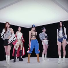 four models are standing in front of a black background and one is wearing white boots