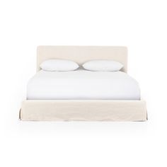 a white bed with two pillows on top of it