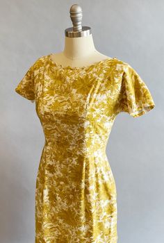 "1950s cotton sateen very fitted day dress. Ivory ground with an all over mustard brush stroke floral print. The neckline is pointed scallops. Top-stitched seams across the bodice, as well as form fitting vertical seams front and back. Cap sleeves, a V-back, with a metal zipper and hook and eye closure. Size- Small Bust - 34\" Waist - 27\" Hips - 39\" Length - 39\" Label: Janice Jr. Condition: Excellent vintage condition. All vintage is sold in \"as-is\" condition. We do our best to inspect, cor Fitted Yellow Dress In 1950s Style, Yellow Fitted Dress In 1950s Style, Fitted Mustard Cotton Dress, Fitted Vintage Mustard Dress, Mustard Fitted Cotton Dress, Mustard Fitted Floral Print Dress, 50s Housewife Dress, Fitted Mustard Floral Print Dress, Fitted Yellow 1950s Dresses