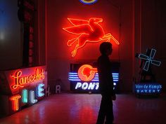 a man standing in front of neon signs