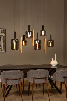 a dining room table with chairs and lights hanging from the ceiling