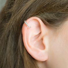 a close up of a person wearing a pair of ear piercings on their ears