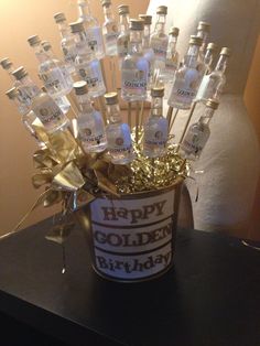 there is a bucket full of bottles with happy birthday messages in them on the table