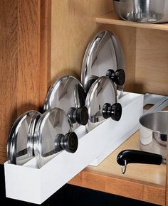 pots and pans are stored in the cabinet drawer for storage or to be put on