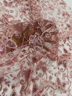 pink and gold sequins on white sheer fabric with floral design in the center