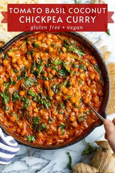 a skillet filled with chickpeas and spinach on top of a table