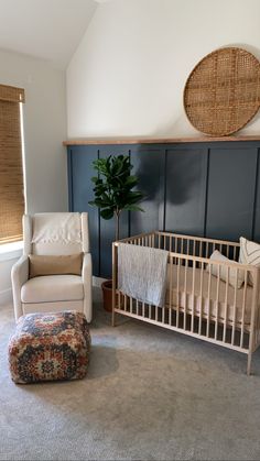 a baby's room with a crib, chair and ottoman