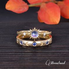 two gold rings with blue and white stones are sitting next to each other on a table