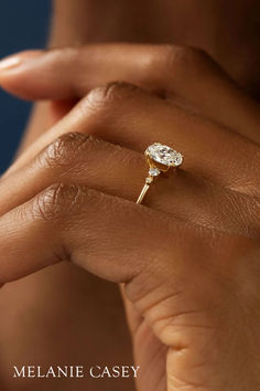 a close up of a person's hand with a ring on her finger and the words melanie casey written below it