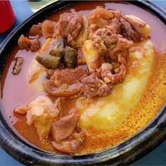 a bowl filled with meat and vegetables on top of a table