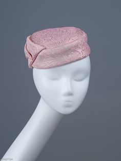 Jackie is a chic, elongated button-shape fascinator completed with a large charismatic bow. The mini hat sits comfortably on the top of your head and should be worn slightly towards right. This  headpiece is hand formed and sewed, making it an exclusive design. This artisan cocktail fascinator will appeal most when worn to complement classic outfits comprising cream, gold or shades of pink. *Handmade item *Style: Jackie *One size fits all *Fabric: pink silk, gold jacquard *Ships worldwide from Poland *More products available on www.joremi.co.uk For the customisation option, please contact me via 'Request a custom order' button at the top of the page. Please note that due to the nature of this handmade artisan headwear, making a second entirely identical item is not possible. We can discuss Spring Headband With Pinched Crown, Vintage Structured Crown Fascinator, Vintage Fascinator With Structured Crown, Vintage Formal Costume Headband, Vintage Formal Headband Costume Hat, Evening Fitted Headband Fascinator, Fitted Hat With Bow And Curved Brim, Fitted Evening Headband Fascinator, Fitted Evening Fascinator Headband