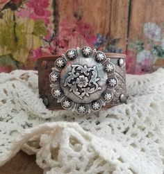 "v'¯) .`*.¸.*' ★ ★ Beautiful RuStiC leather bracelet, always with a FeMiNinE flair ❤ ¸.*'.*'¨) ¸. (¸.*'(¸.*' (¸. Simply gorgeous color combo! This DESIGN ❤~ The natural leather floral embossed cuff was painted silver over bronze, then distressed and sealed. A large beautiful intricate antique silver floral concho sits centered. Rivets were set individually into the leather. The width of the cuff is approximately 1 1/4\" wide. BRACELET SIZING INFO: My women's bracelets are approximately 8 1/2 inc Western Concho Bracelets For Festival, Western Style Concho Bracelets For Festivals, Adjustable Western Cuff Bracelet For Festivals, Adjustable Western Style Cuff Bracelet For Festivals, Adjustable Western Style Festival Cuff Bracelet, Western Style Adjustable Cuff Bracelet For Festivals, Adjustable Concho Cuff Bracelet For Festival, Artisan Adjustable Concho Cuff Bracelet, Rustic Concho Cuff Bracelet For Festival