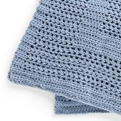 a blue crocheted blanket folded on top of each other