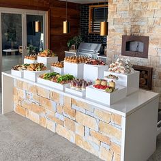 an outdoor buffet is set up with food and drinks on the bar top, along with other foods