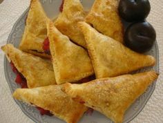 several pastries on a plate with black olives