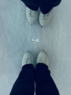 two people standing in the snow with their feet up and one person wearing white shoes