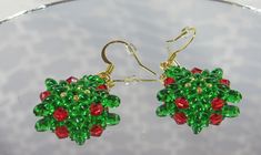 These hand beaded earrings are constructed with translucent green super duos, red bi cones, and galvanized gold tone seed beads.  They have standard gold tone ear wires that are attached with steel thread guardians. Silicone stops are included. Dimensions: 1 inch long and 1 inch wide. Hand Beaded Earrings, Super Duo, Green And Red, Bead Jewellery, Seed Bead Jewelry, Green Bead, Hand Beading, Seed Bead, Ear Wires