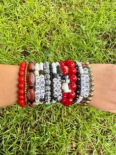 Georgia game day bracelet stack. 5 bracelet strands included in one stack. Multi material beads on elastic cord. One size fits all. Prices are based on bead material and size. Game Day Team Spirit Stretch Bracelet With Round Beads, Adjustable Red Stacked Beaded Bracelets, Adjustable Stacked Red Beaded Bracelets, Adjustable Stacked Black Beaded Bracelets, Black Team Spirit Adjustable Beaded Bracelets, Black Adjustable Beaded Bracelets Team Spirit Style, Black Adjustable Beaded Bracelets For Team Spirit, Game Day Black Wristband With Letter Beads, Adjustable Team Spirit Stretch Bracelet For Game Day