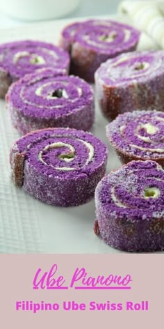 purple cake rolls with white frosting and sprinkles in the middle on a table