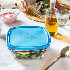 there is a blue lunch box on the table with other plates and utensils