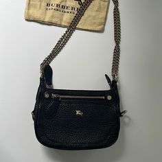 The Bag Has A Strap That Is Convertible From A Crossbody To A Shoulder, Logo Placard At Front, Tonal Canvas Lining, Single Pocket At Interior With Zip Closure, Front Zip Pocket And Zip Closure Top. Purchased At Burberry. This Is Authentic. It’s In Very Good Condition And Used Less Than A Handful Of Times. There Are Very Light Scratches At Hardware, Slight Residue At Interior Pocket. The Size Is Perfect For An Evening Bag Or Day. The Dimensions Are: 9 X6.5 X 2.5 Burberry Black Purse, Burberry Black, Black Pebbles, Leather Purse, Burberry Bag, Chain Strap, Pebbled Leather, Leather Purses, Evening Bags