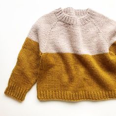 a yellow and white sweater is shown on a white surface, with the top half showing