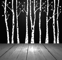 a black and white photo of trees with no leaves on the branches, in front of a dark background