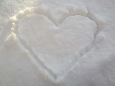 a heart made out of snow sitting on top of a bed