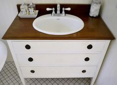 a white sink sitting on top of a wooden counter