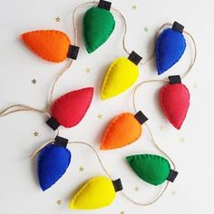 colorful christmas lights hanging from string on white background