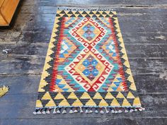 a multicolored rug is laying on the ground