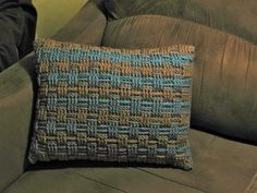 a blue and brown pillow sitting on top of a couch