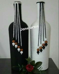 two white vases with black and red beads on them