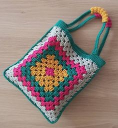 a crocheted bag sitting on top of a wooden table