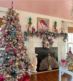 a decorated christmas tree in front of a fire place with ornaments on the mantel