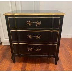 a black and gold painted chest of drawers