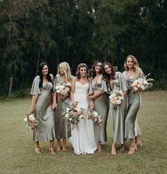 a group of women standing next to each other on top of a lush green field