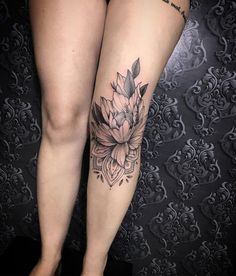 a woman's legs with a flower tattoo on it and the bottom half of her leg